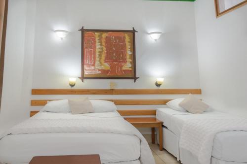 two beds in a room with lights on the wall at Hotel Casa Amelia in Flores