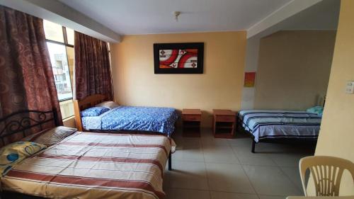 een hotelkamer met 2 bedden en een raam bij Hostal refugio's in Ica