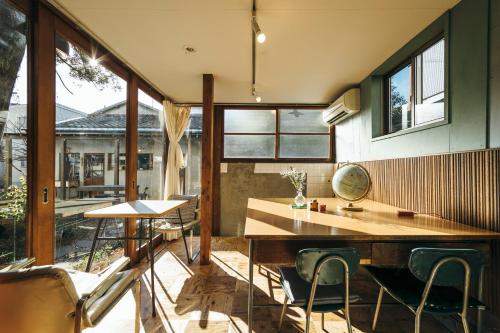 a kitchen with a wooden table and chairs in a room at Torii-Kuguru in Okayama