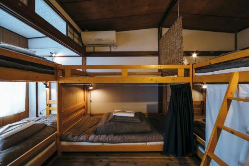 1 Schlafzimmer mit 2 Etagenbetten in einem Zimmer in der Unterkunft Torii-Kuguru in Okayama