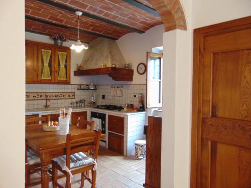 a kitchen with a wooden table and a wooden door at Agriturismo Circugnano in Grassina