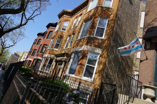 an old brick house with a flag in front of it at Wrigley Hostel - Chicago in Chicago
