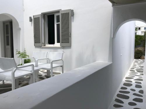 a white chair sitting in front of a white wall at Room 11 in Mikonos