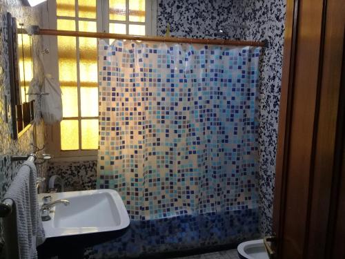 a bathroom with a shower curtain and a sink at Casa de Campo Finca La Superiora in La Consulta