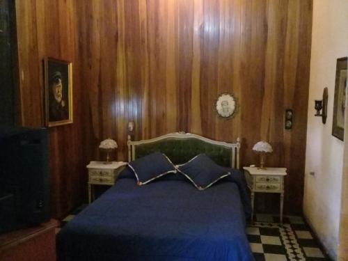 um quarto com uma cama azul e duas mesas de cabeceira em Casa de Campo Finca La Superiora em La Consulta