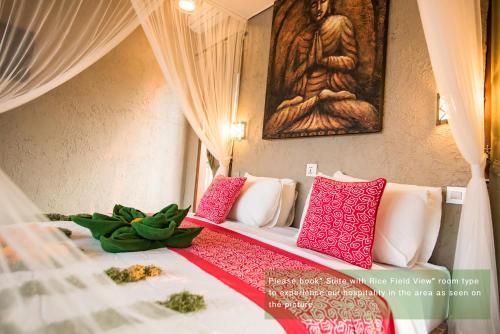 a bedroom with a bed with pink and white pillows at Ayu Duwur Beji in Ubud