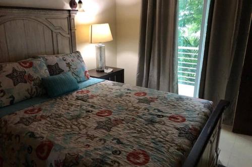 a bedroom with a bed with a floral bedspread and a window at Havensight Haven 1BR/1.5BA in Estate Thomas