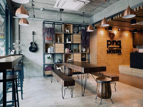 een kamer met een piano en een tafel en stoelen bij Pinghostel in Chiang Mai