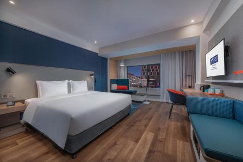 a hotel room with a large bed and a desk at Holiday Inn Express Ningbo City Center by IHG in Ningbo