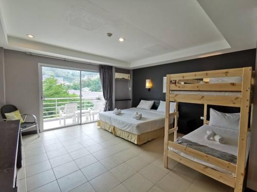 a bedroom with two bunk beds and a balcony at The Natural Resort in Patong Beach