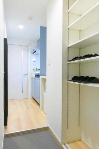 a room with white walls and a hallway with shelves at Sou in Fujisawa