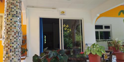 an open door in a room with potted plants at Chez Mera Self Catering in La Digue