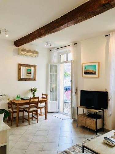 un salon avec une table et une télévision dans l'établissement Carousel, à Antibes