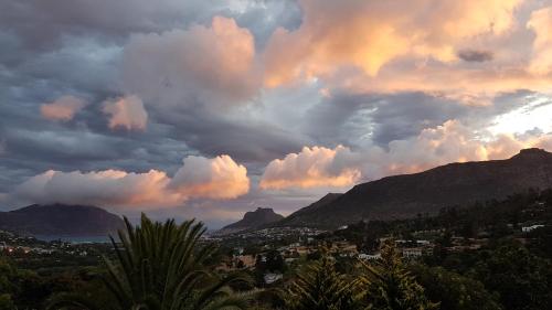 Victorskloof Lodge في هوت باي: السماء غائمة مع المدينة والجبال في الخلفية