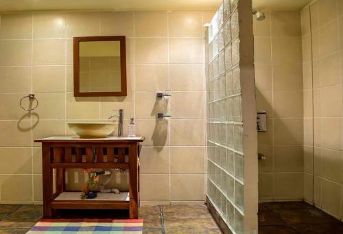La salle de bains est pourvue d'un lavabo et d'un miroir. dans l'établissement Tribal Hills Mountain Resort, à Puerto Galera