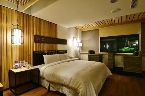 a bedroom with a large bed and a television at OUGE Motel Kaohsiung in Kaohsiung