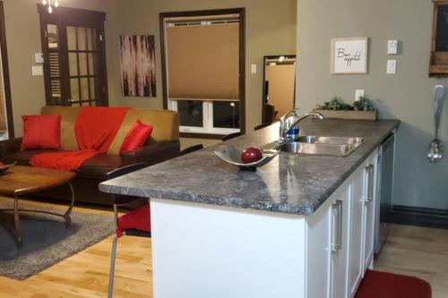 a kitchen with a sink and a living room at 1-Bedroom Apartment Bellisimo AG by Amazing Property Rentals in Gatineau
