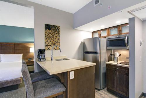a small kitchen in a hotel room with a bed at Staybridge Suites Toronto - Vaughan South by IHG in Vaughan