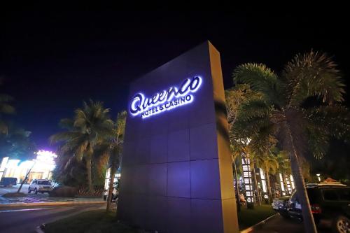 a sign that says chrysler dealership in front of palm trees at Queenco Hotel & Casino in Sihanoukville