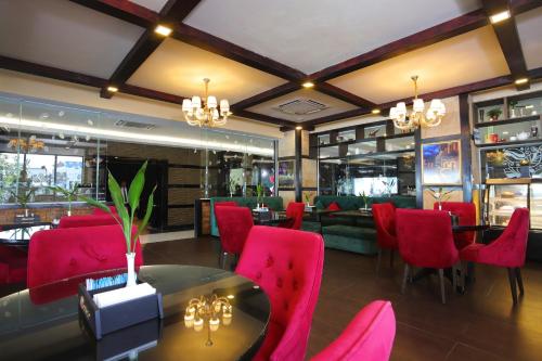 a dining room with red chairs and a table in a restaurant at Queenco Hotel & Casino in Sihanoukville