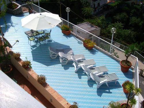 an overhead view of a swimming pool with chairs and an umbrella at Le Terrazze di Cristina in Vietri sul Mare