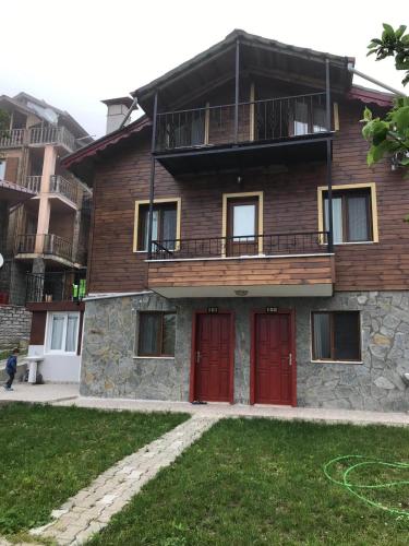 a house with red doors and a balcony at Ayder Palas Apart Hotel in Ayder Yaylasi