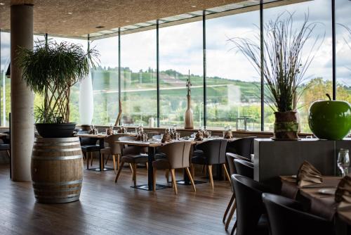 a restaurant with tables and chairs and large windows at Hotel de l'Ecluse Superior in Stadtbredimus