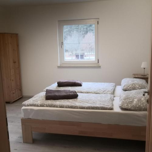 two beds in a room with a window at Ferienhaus am Bach mit großem Garten in Deuerling