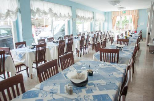 une salle à manger avec des tables et des chaises bleues et blanches dans l'établissement Albergo Villa Miraggio, à Rimini