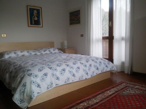 sypialnia z łóżkiem z niebiesko-białą kołdrą w obiekcie Boschettoresidence w mieście Perugia