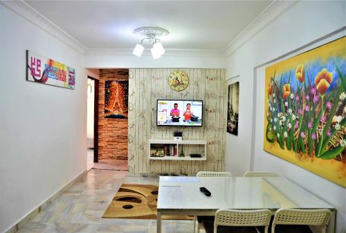 a living room with a table and a tv on a wall at Awedee Homestay Putrajaya in Putrajaya
