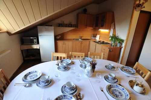 a dining room table with plates and dishes on it at Privat Greenland in Liptovský Mikuláš