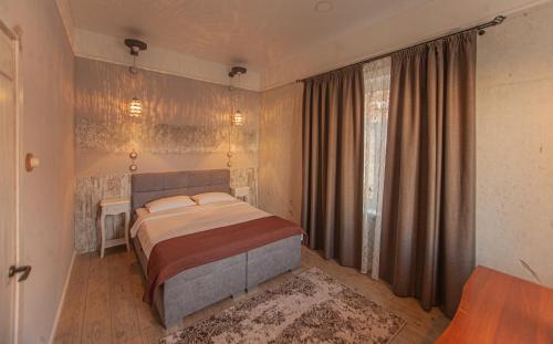 a bedroom with a bed and a large window at Biplan Hotel in Daugavpils