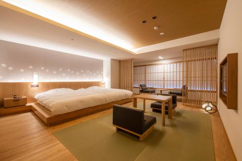 a bedroom with a large bed and a desk at Shosenkaku Kagetsu in Yuzawa