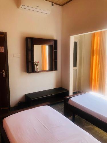 a bedroom with two beds and a mirror at Fernando's Inn in Negombo