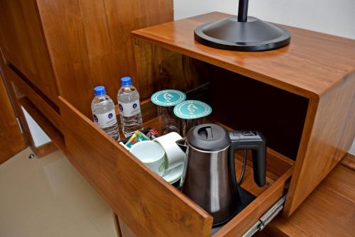 a cupboard with a tea kettle and water bottles at Goldi Sands Hotel in Negombo