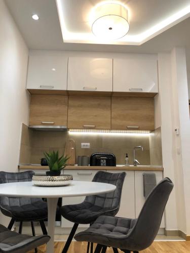 a kitchen with a white table and chairs at GOMAX Apartmani Zlatibor in Zlatibor