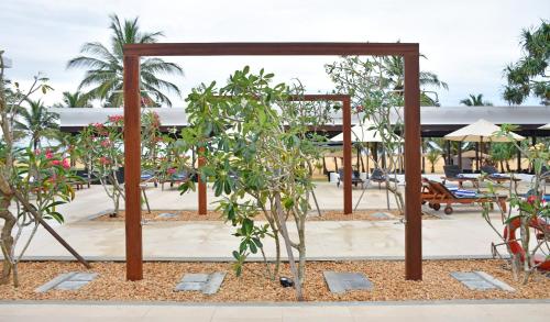 a garden with trees and a wooden structure at Goldi Sands Hotel in Negombo
