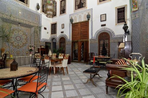 une chambre avec des tables et des chaises dans un bâtiment dans l'établissement Riad Le Patio De Fes, à Fès