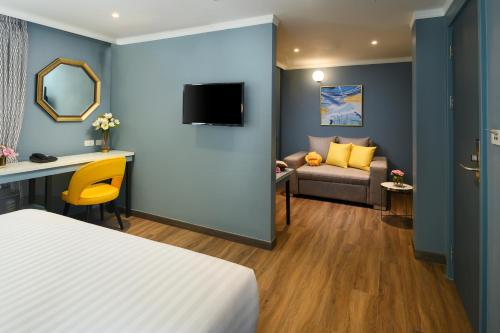 a hotel room with a bed and a couch at The Mulberry Bangkok Khaosan Road in Bangkok