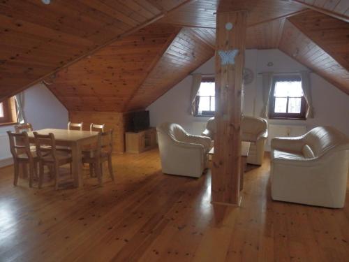 ein Wohnzimmer mit einem Tisch und Stühlen im Dachgeschoss in der Unterkunft Pension Cortina in Pec pod Sněžkou