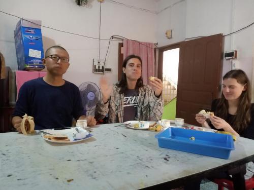 a group of people sitting at a table eating food at Green Homestay Kolkata - Prefer International Guest - Attach Bath - Paid Kitchen in Kolkata