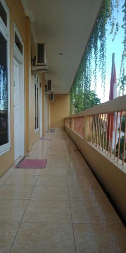 a hallway of a building with a balcony and flags at Orange Hotel in Labuan Bajo