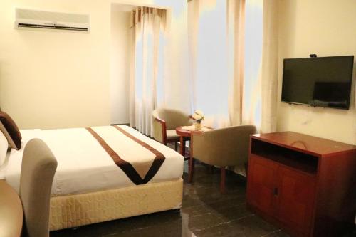 um quarto de hotel com uma cama e uma televisão de ecrã plano em Rimal Suites Apartments em Salalah