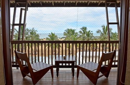 a balcony with a table and chairs and a view of the ocean at Goldi Sands Hotel in Negombo