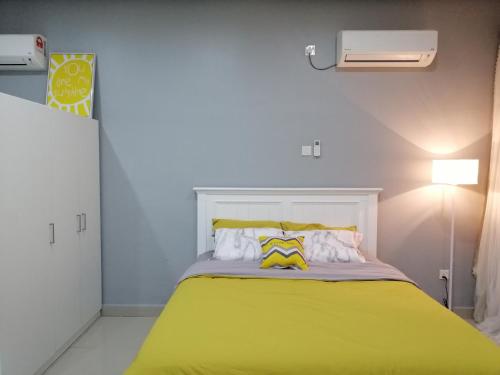 a bedroom with a bed with a yellow blanket at Johor Austin TOPPEN Romantic 2pax WIFI Homestay in Johor Bahru
