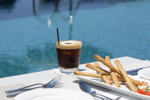 a plate of food with a drink and french fries at Lagouvardos Village Hotel in Marathopoli