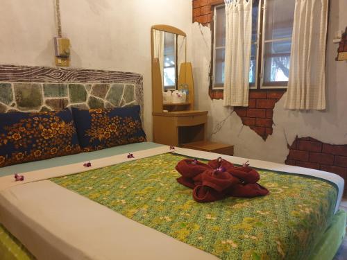 a bedroom with a bed with flowers on it at P P Garden Home Bungalow in Phi Phi Don