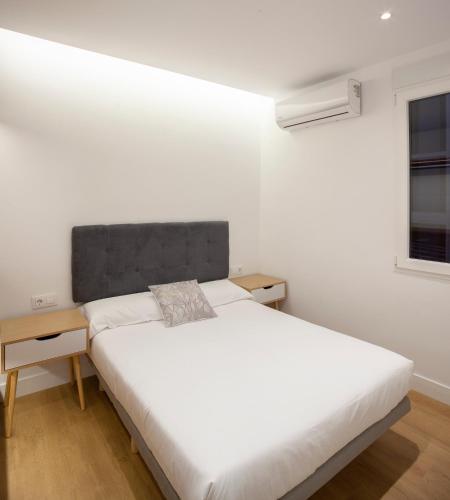 een slaapkamer met een groot wit bed en een raam bij Luxury flat Chamberi IV in Madrid