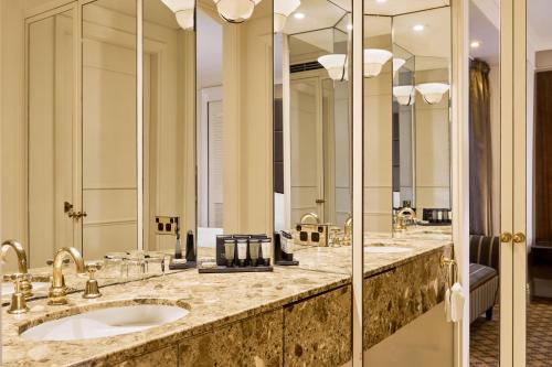 a bathroom with two sinks and two mirrors at Stamford Plaza Melbourne in Melbourne